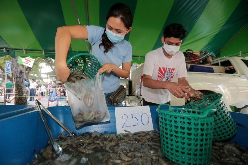 Ein-Kunde-kauft-Garnelen-auf-einem-provisorischen-Markt-an-der-Kasetsart-University-in-Bangkok.jpg