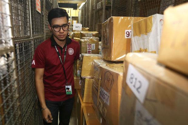 An official from the Food and Drug Administration (FDA) inspects boxes containing illicit drugs being kept at an FDA warehouse in Ayutthaya on Tuesday. The drugs are to be incinerated on June 24. (Photo by Jiraporn Kukakan)